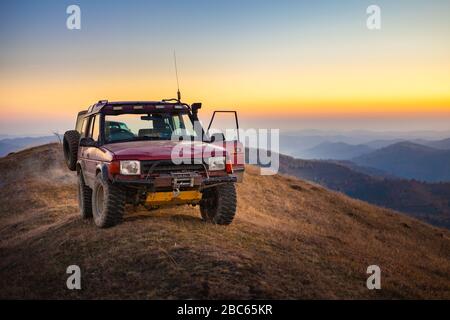 Geländewagen, das durch Berge und Hügel fährt Stockfoto