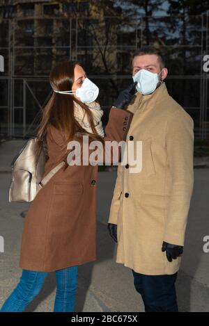 Kaukasische Paare tragen Masken und schwarze Nitrilhandschuhe, die auf dem Straßen-selektiven Fokus laufen Stockfoto