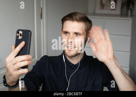 Junger Mann, der im Home Office Videoanruf über den Computer hat. Bleiben Sie zu Hause und arbeiten von zu Hause Konzept während Coronavirus Pandemie. Stockfoto