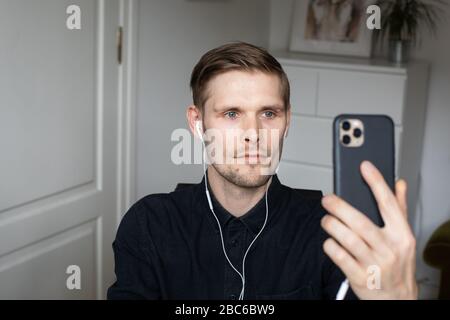 Junger Mann, der im Home Office Videoanruf über den Computer hat. Bleiben Sie zu Hause und arbeiten von zu Hause Konzept während Coronavirus Pandemie. Stockfoto