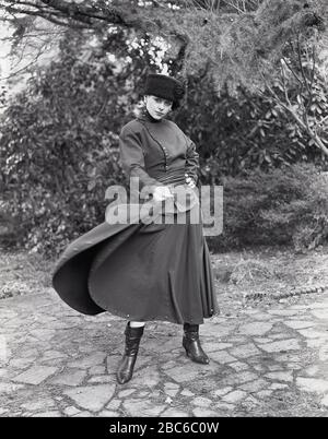 1960er Jahre, historisch, eine Dame außerhalb der neuesten russischen Militärmode oder 'Kosakenmode', bestehend aus Fellhut, hochhalsigem Oberteil, langem Rock und Stiefeln, England, Großbritannien. Eine Gruppe großer russischer Militärkrieger, die für ihre Tapferkeit bekannt sind, das Wort "Cossack" leitet sich von dem turksprachigen Begriff "Kajak" ab, der "Freimann" oder "Abenteurer" bedeutet. Stockfoto