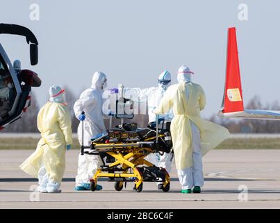 02. April 2020, Sachsen, Dresden: Medizinisches Personal steht beim Eintreffen eines Rettungsflugzeugs mit einem schwer erkrankten Covid 19-Patienten aus Frankreich auf dem Asphalt am Internationalen Flughafen Dresden. Das Flugzeug Learjet 45 kam aus Metzger und landete am Nachmittag auf dem Flughafen Dresden. Wie das Universitätsklinikum Dresden auf Anfrage mitteilte, sollen am Abend zwei weitere französische Patienten eintreffen. Das Fachkrankenhaus Coswig, das Krankenhaus Dresden-Friedrichstadt und das örtliche Universitätsklinikum würden jeweils einen der Patienten versorgen. Über ihre Identität wurde nichts enthüllt. Sachsen hatte bereits Anzeige gemacht Stockfoto