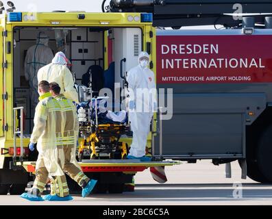 02. April 2020, Sachsen, Dresden: Ein schwer erkrankter Covid 19-Patient aus Frankreich wird von einem Ambulanzflugzeug zum Krankenwagen am Internationalen Flughafen Dresden transportiert. Das Flugzeug Learjet 45 kam aus Metzger und landete am Nachmittag auf dem Flughafen Dresden. Wie das Universitätsklinikum Dresden auf Anfrage mitteilte, sollen am Abend zwei weitere französische Patienten eintreffen. Das Fachkrankenhaus Coswig, das Krankenhaus Dresden-Friedrichstadt und das örtliche Universitätsklinikum versorgen jeweils einen der Patienten. Über ihre Identität ist nichts bekannt geworden. Sachsen hatte bereits zugelassen e Stockfoto