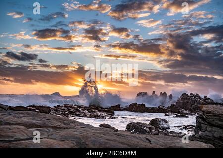 Südafrika, Cape St Francis, Sun Going Down, über den Indischen Ozean und die Wellen schlagen auf den Rocks. Stockfoto