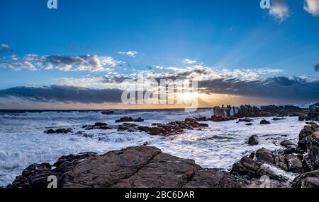 Südafrika, Cape St Francis, Sun Going Down, über den Indischen Ozean und die Wellen schlagen auf den Rocks. Stockfoto