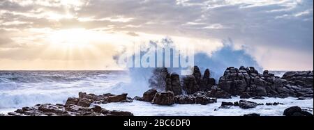 Südafrika, Cape St Francis, Sun Going Down, über den Indischen Ozean und die Wellen schlagen auf den Rocks. Stockfoto