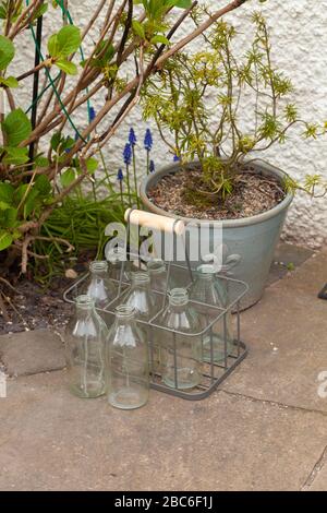 Leere Milchflaschen vor der Haustür. Stockfoto