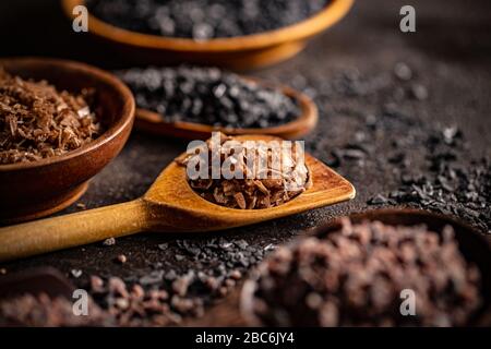 Geräuchertes Maldon-Salz in Holzlöffel und anderen Gourmetsalzen Stockfoto