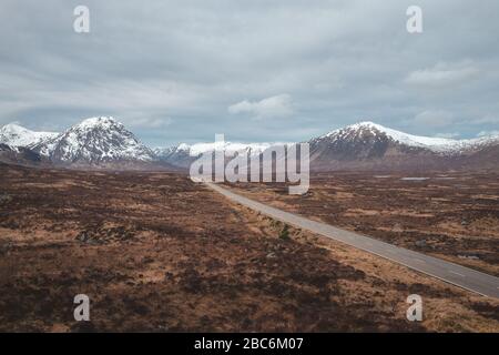 Straße, die durch die schottischen Highlands von Glen Coe führt, schneebedeckte Berge und Tal. Schottland Stockfoto