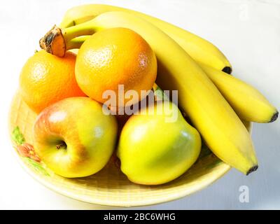 Obstschale mit braeburn Äpfeln Orangen und Bananen auf einem weißen Tischtuch Stockfoto