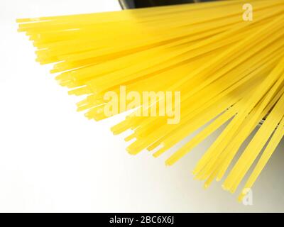 100 Gramm Spaghetti in einer Edelstahlschale auf einer weißen Tischdecke Stockfoto