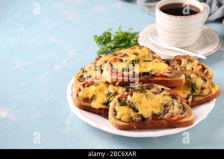 Heiße Sandwiches mit Tomaten, Champagner, Käse und Tasse Kaffee auf hellblauem Hintergrund, Copy Space Stockfoto