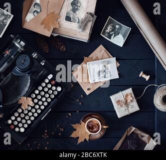 MOSKAU, RUSSLAND - 3. APRIL 2020: Illustratives redaktionelles Foto mit alten Fotos von Mann und Frau in der Nähe der alten russischen Schreibmaschine, Tasse Kaffee, dunkles Cho Stockfoto