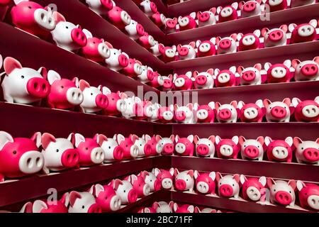 Viele Spielzeugschweine befinden sich in Regalen im Raum. Stockfoto