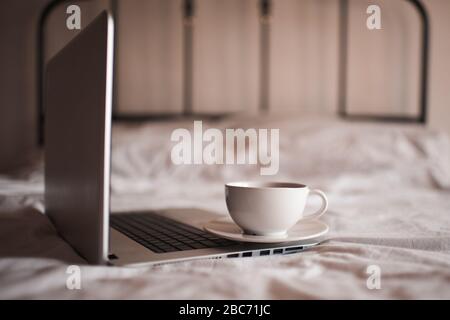 Arbeiten zu Hause. Tasse Kaffee auf offenem Computer im Nahbereich. Guten Morgen. Soziale Distanzierung. Stockfoto