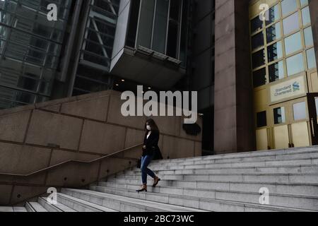 Hongkong, CHINA. April 2020. Maskierte Frau geht die Treppe hinunter, die außerhalb DER STANDARDMÄSSIGEN GECHARTERTEN BANK Headquarter in Central liegt. Die globalen Coronavirus Infektionen haben gerade 1 Million erreicht und verbreiten sich weiter mit alarmierender Geschwindigkeit, die kein Anzeichen einer Dissipation zeigt. PANDEMIE aus Wuhan City CHINA hat die Weltwirtschaft verwüstet und weiterhin Tausende von Leben auf der Planetenskala gefordert.April-3, 2020 Hongkong.ZUMA/Liau Chung-ren Credit: Liau Chung-ren/ZUMA Wire/Alamy Live News Stockfoto