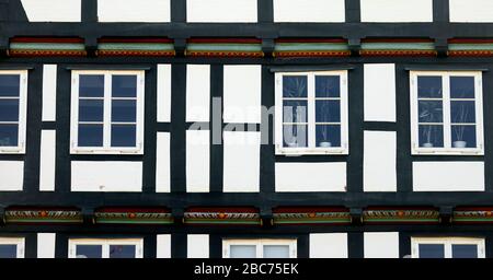 Abschnitt eines Fachwerkhauses mit schwarzen Balken und eingebauten Fenstern Stockfoto