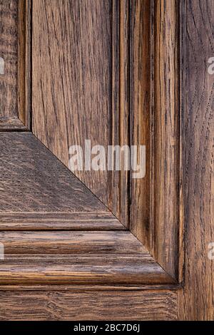 Nahaufnahme von einem Detail aus Täfelung und Holzkorn auf einer dunklen Holztür Stockfoto