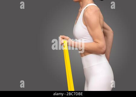 Nahaufnahme einer Frau, die während des Trainings und der Übung ein Widerstandsband verwendet. Stockfoto