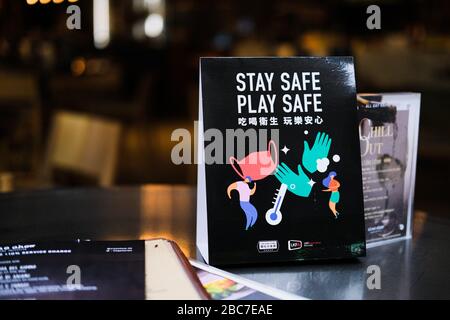 Hongkong, China. April 2020. Auf dem Bartisch wird eine Nachricht mit der sicheren Spielkarte angezeigt. Die Regierung in Hongkong hat eine zweiwöchige Schließung von Pubs und Bars angeordnet, um die sozial distanzierenden Regeln zu verschärfen. Kredit: Keith Tsuji/ZUMA Wire/Alamy Live News Stockfoto