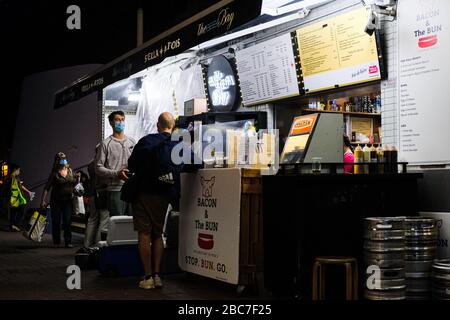 Hongkong, China. April 2020. Personen mit einer chirurgischen Gesichtsmaske sind außerhalb der stehenden Leiste zu sehen. Die Regierung in Hongkong hat eine zweiwöchige Schließung von Pubs und Bars angeordnet, um die sozial distanzierenden Regeln zu verschärfen. Kredit: Keith Tsuji/ZUMA Wire/Alamy Live News Stockfoto