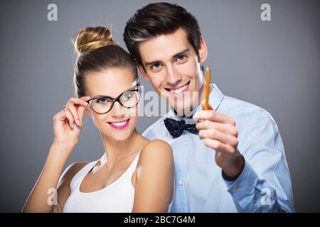 Junges Paar steht auf grauem Hintergrund Stockfoto