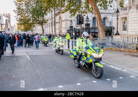Polizei-Motorradfahrer auf der nahe gelegenen 10 Downing Street. Das Gerät stellt Motorradbegleiter zur Verfügung, um den Verkehr von Protesten zu stoppen und abzulenken Stockfoto