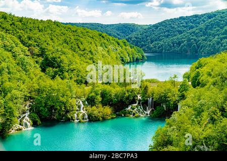 Wasserfälle, die zwischen Seen und von bewaldeten Hügeln umgeben, Nationalpark Plitvicer Seen, Kroatien, Europa. Mai 2017. Stockfoto