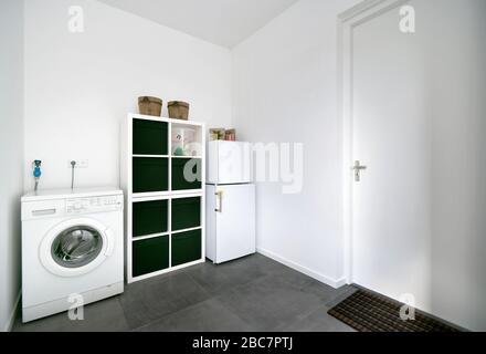 Die weiße Waschküche mit Waschmaschine und Kühlschrank in einem niederländischen Haus Stockfoto