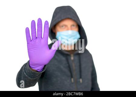 Konzept für das Gesundheitswesen und die Medizin. Mann in hygienischer Schutzmaske und Handschuhe gesturzender Anschlag, Warnung vor Coronavirus-Epidemie, COVID-19 Stockfoto