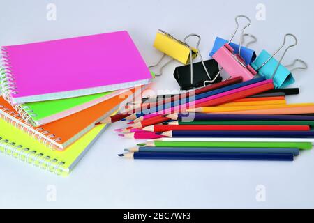 Farbpads, Bleistifte und Büroklammern auf weißem Hintergrund Stockfoto