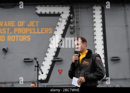 US-Navy Capt Brett Crozier, kommandierender Offizier des Flugzeugträgers USS Theodore Roosevelt, spricht die Besatzung während eines ganzhändigen Anrufs auf dem Flugdeck am 15. November 2019 im östlichen Pazifischen Ozean an. Crozier wurde vom 31. März 2020 entlastet, nachdem er einen vierseitigen Brief an seine Vorgesetzten geschrieben hatte, in dem er mit ihnen plädierte, Maßnahmen zu ergreifen, um die Verbreitung der COVID-19-Fälle auf seinem Schiff zu verringern. Stockfoto