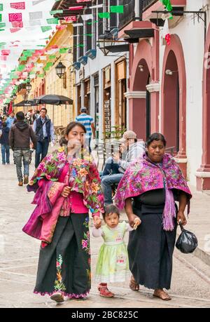 Zwei Frauen und Kinder der Maya, die ein traditionelles Kleid tragen, in der Calle Real de Guadalupe, Fußgängerzone in San Cristobal de las Casas, Chiapas, Mexiko Stockfoto