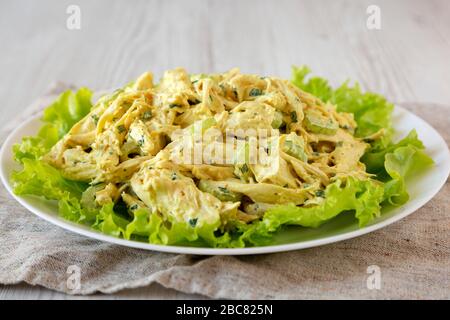 Hausgemachter Coronation Chicken Salat auf weißem Teller, Seitenansicht. Nahaufnahme. Stockfoto