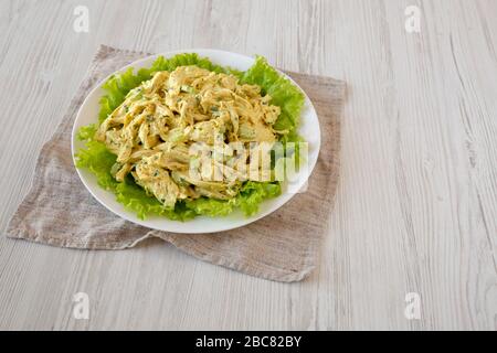 Hausgemachter Coronation Chicken Salat auf weißem Teller, Seitenansicht. Leerzeichen für Text. Stockfoto