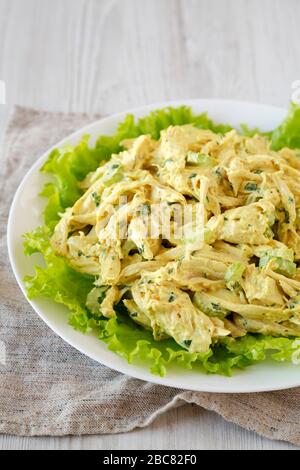 Hausgemachter Coronation Chicken Salat auf einem weißen Teller, niedriger Blickwinkel. Stockfoto