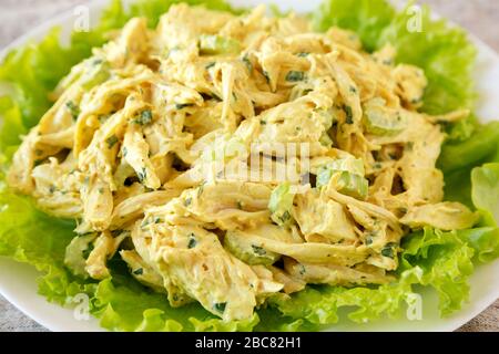 Hausgemachter Coronation Chicken Salat auf weißem Teller, Seitenansicht. Nahaufnahme. Stockfoto