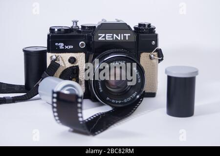 Alte 35mm-Filmkamera der Schule und Kameraobjektive mit Filmbehältern und Filmbändern auf weißem Hintergrund isoliert Stockfoto
