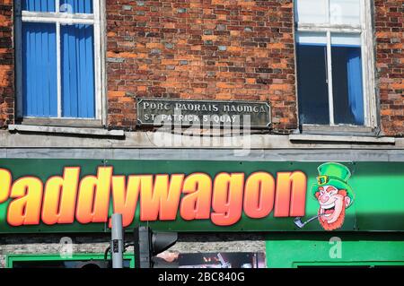 Schild für St.Patrick's Quay, in Gälisch und Englisch an einer Wand in St. Patrick's Quay. Stockfoto