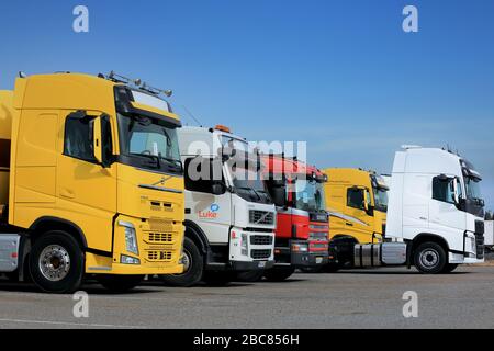 FORSSA, Finnland - 9. April 2017: Line-up der bunten neuen und gebrauchten Volvo und Scania halb LKWas auf Asphalt Hof an einem bewölkten Tag. Stockfoto