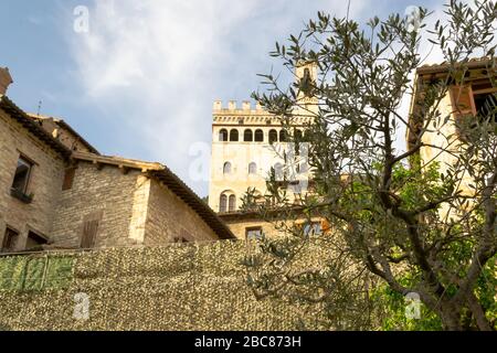 Gubbio, Mittelitalien. Von einer typischen engen Straße dieser Altstadt aus bietet sich ein eindrucksvoller Blick auf die Architektur dieser Stadt mit dem 'Palazzo dei Consoli'. Stockfoto