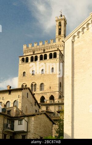 Gubbio, Mittelitalien. Von einer typischen engen Straße dieser Altstadt aus bietet sich ein eindrucksvoller Blick auf die Architektur dieser Stadt mit dem 'Palazzo dei Consoli'. Stockfoto