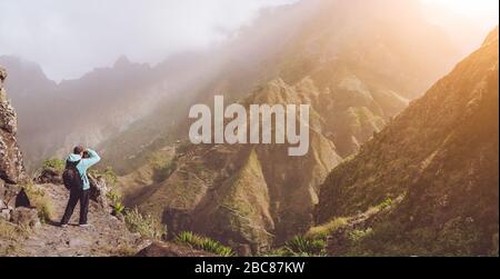 Der Mensch in großer Höhe ist felsig und macht ein Bild von der Berglandschaft vor einer tiefen Schlucht. Warmes Sonnenlicht erfüllte das Tal. Trekking Trail auf Santo A. Stockfoto