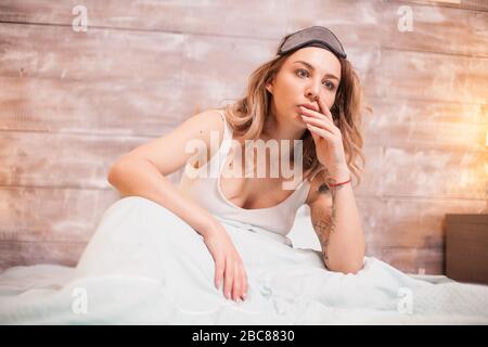 Schöne junge Frau im Schlafzimmer, die an Schlaflosigkeit leidet. Stockfoto
