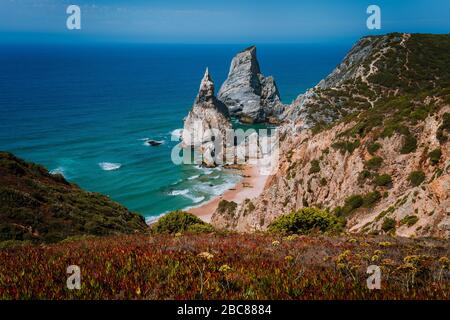 Surreale und bizarre Rocks am Strand Praia da Ursa, Sintra, Portugal. Hoch aufragende Klippen mit goldenem Abendlicht. Atlantikküste in der Nähe berühmter Kabine Stockfoto