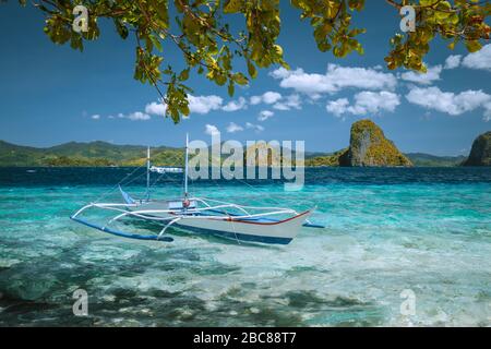 Palawan, Philippinen. Hopping Insel Reise nach El Nido. Unglaublich traumhaften exotischen Landschaft mit traditionellen Filippino banca Boot vertäut in Türkis oc Stockfoto