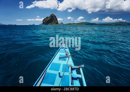 El Nido, Palawan, Philippinen. Traditionelle banca Boot auf dem Weg zu erstaunlichen Pinagbuyatan Insel. Eine kleine runde Insel mit riesigen kalkfelsen ein Stockfoto