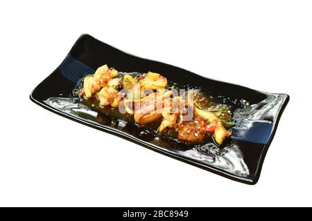 Gegrillter Tintenfisch, der würzige Sauce auf dem Teller anzaugt Stockfoto