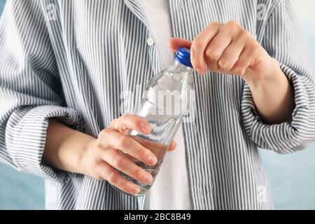 Person im Hemd öffnet eine Flasche, Nahaufnahme Stockfoto