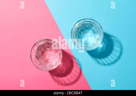 Brille mit Wasser auf zweifarbiges Hintergrundbild, Draufsicht Stockfoto